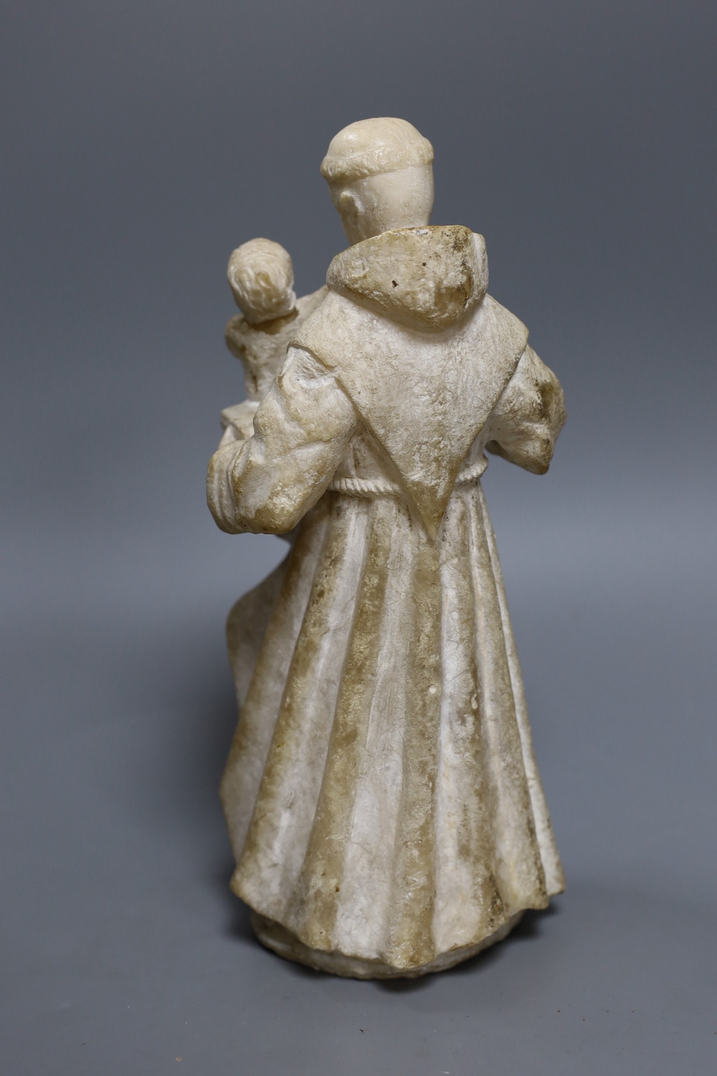 A 19th century carved alabaster group, friar with child 28cm